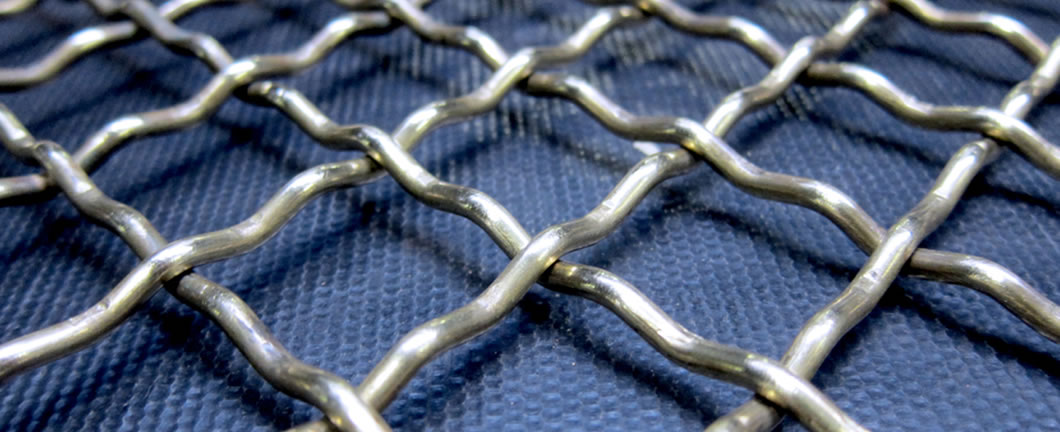 A piece of woven vibrating screen mesh on the blue paper.